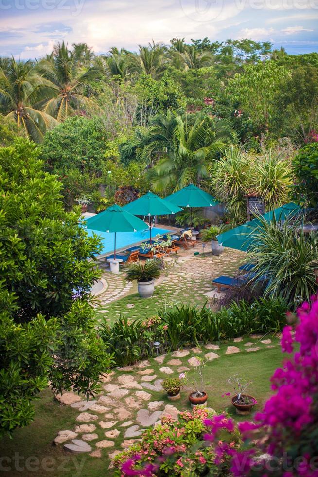 trevlig se av de trädgård och simning slå samman i en mysigt liten hotell foto
