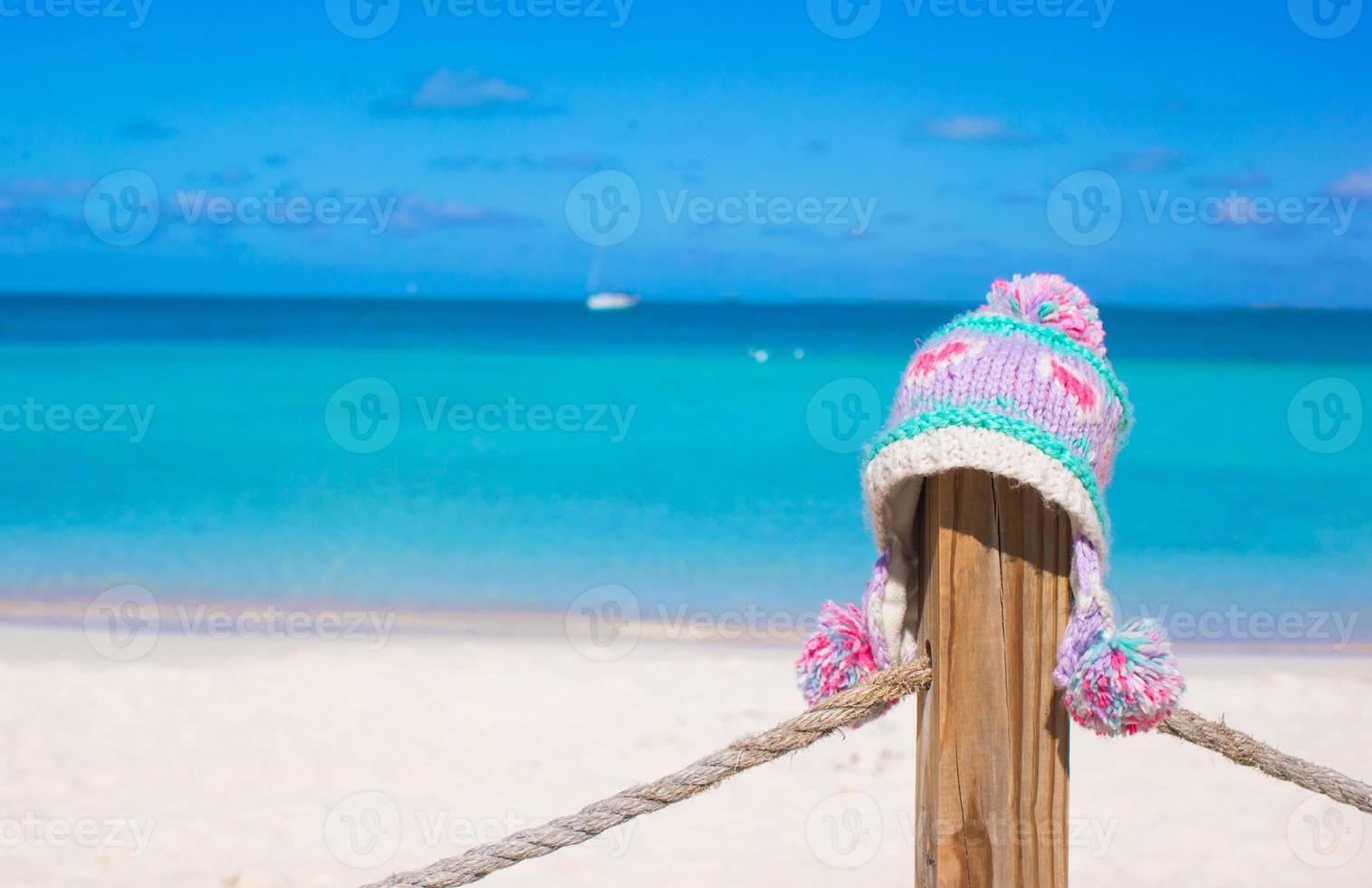 närbild värma stickat keps på staket på tropisk strand foto