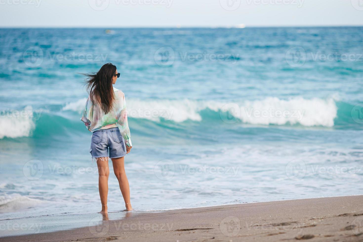 ung Lycklig kvinna gående på de strand foto