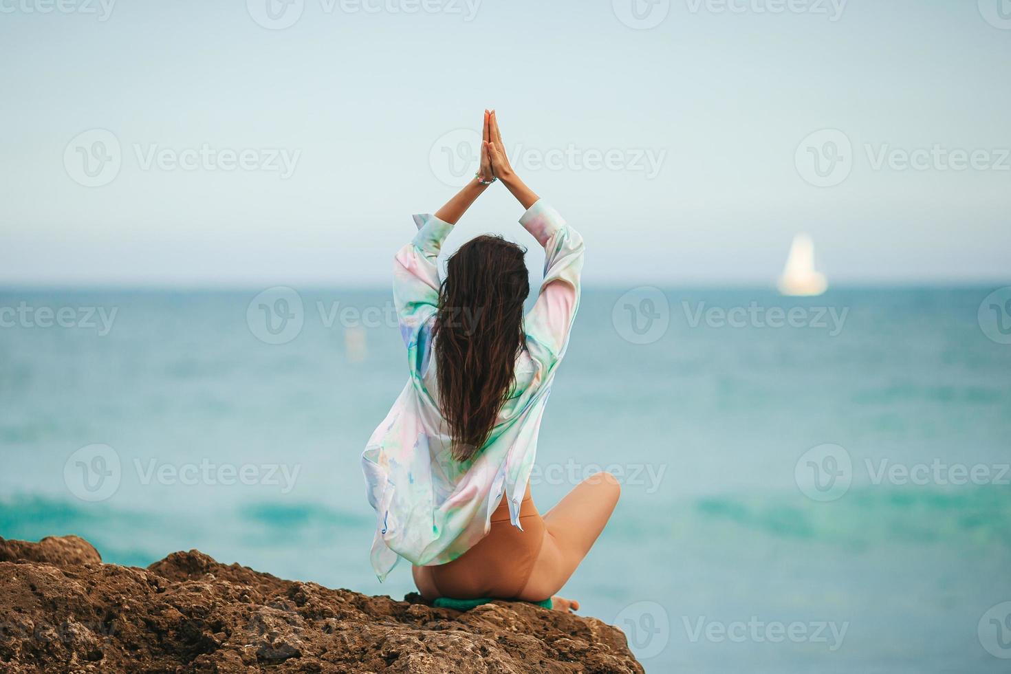 ung kvinna med praktiserande yoga på de strand foto