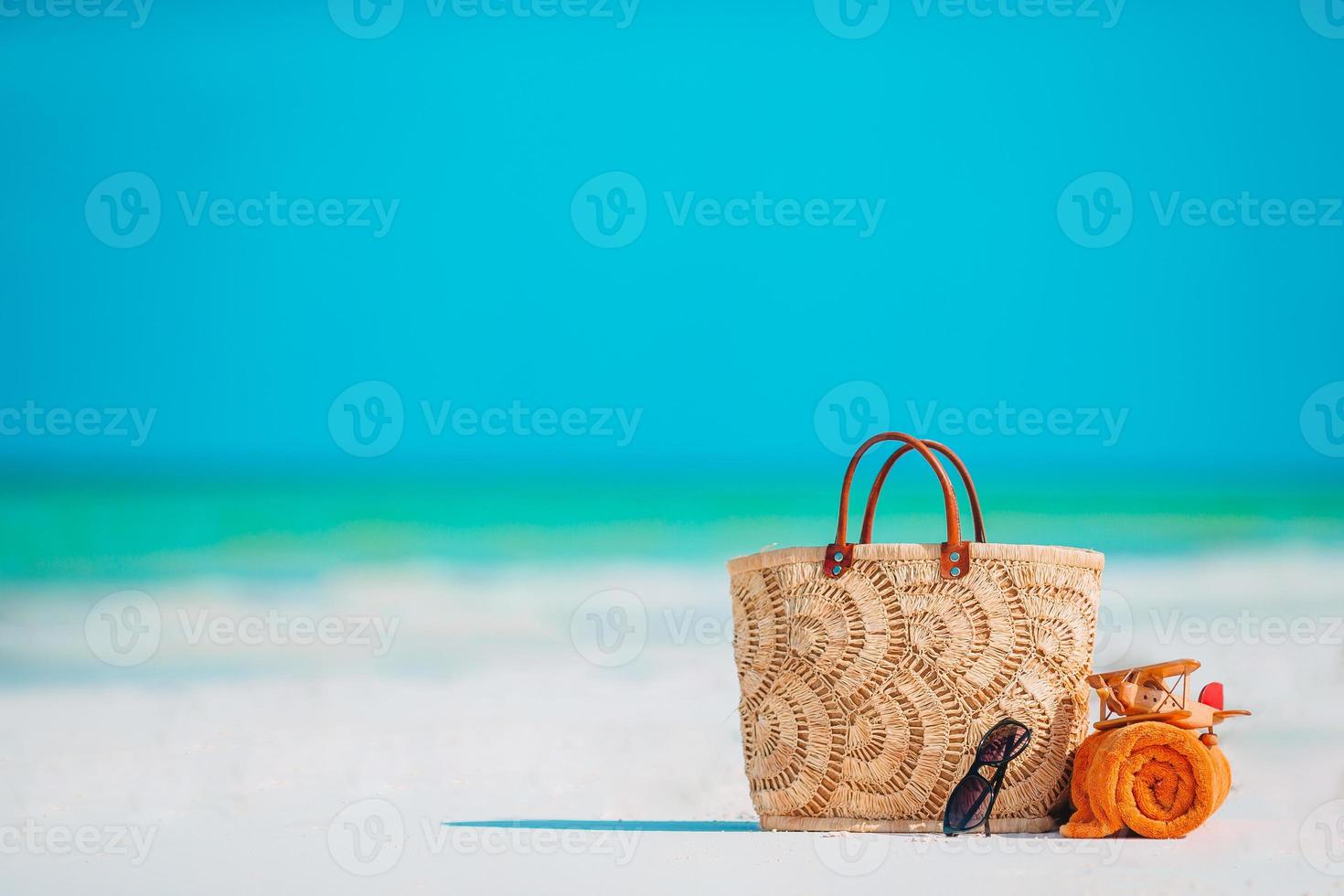 strand Tillbehör - väska, sugrör hatt, solglasögon på vit strand foto