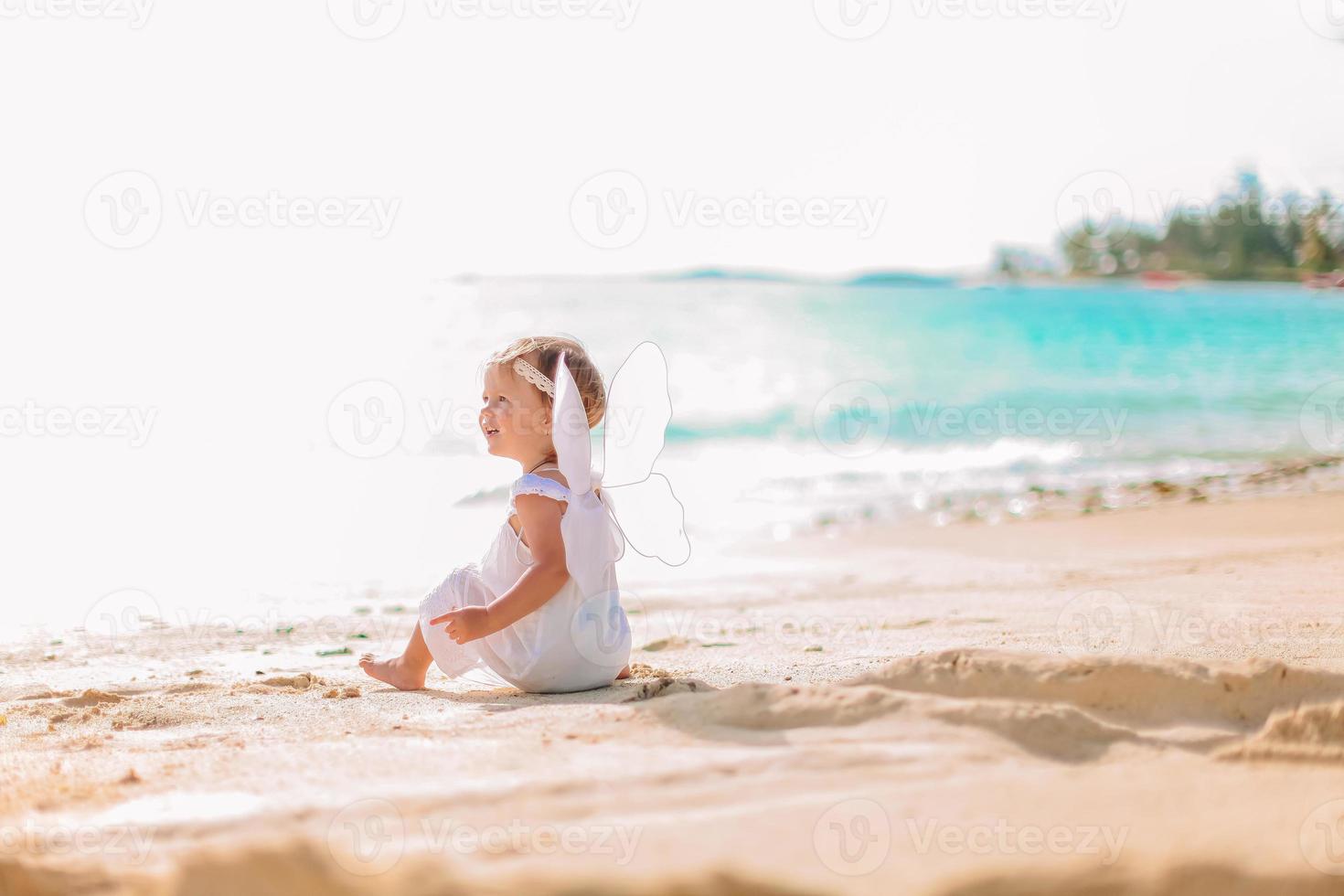 skön ung flicka bär ängel vingar på de strand foto