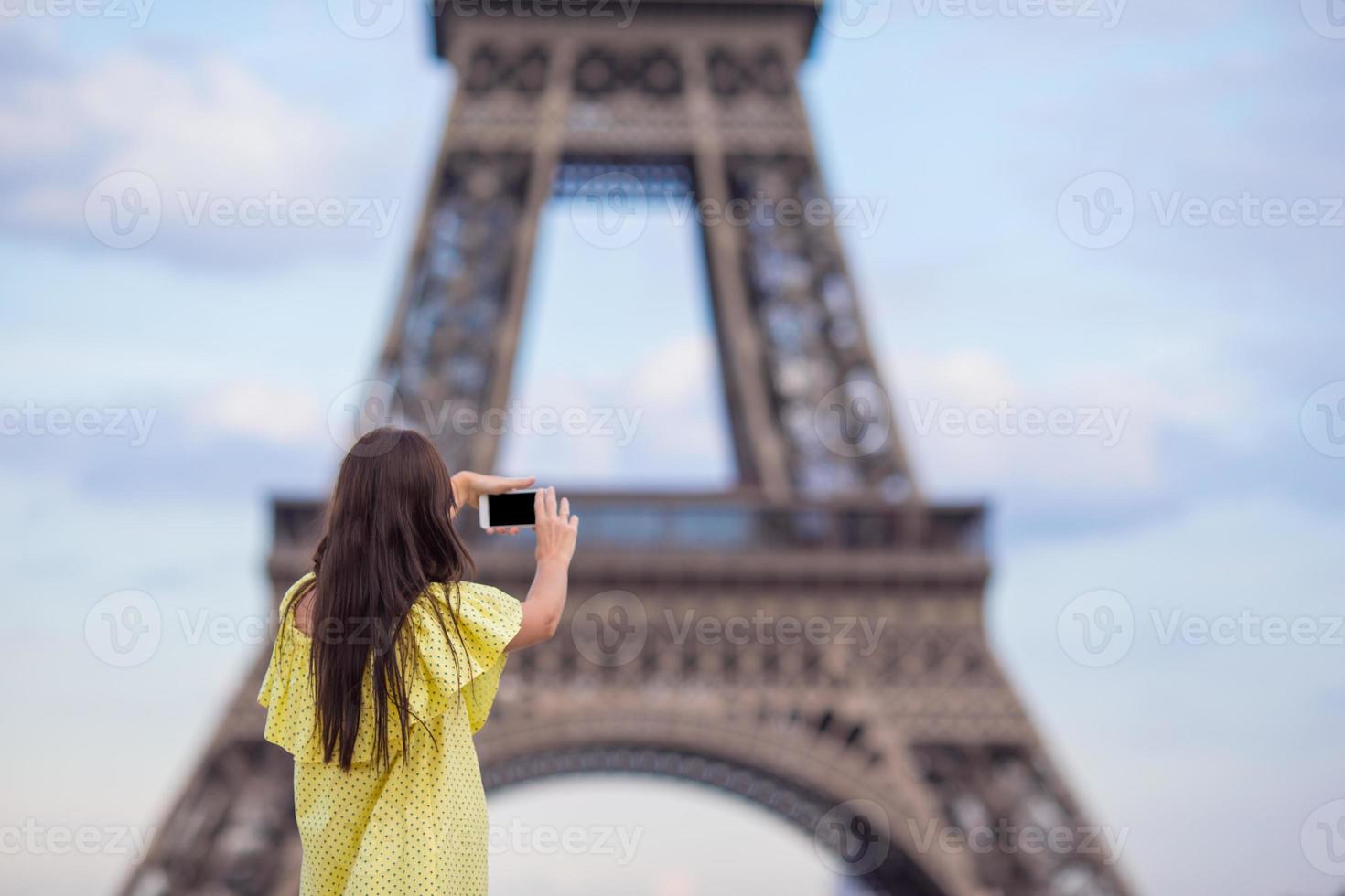 ung kvinna framställning Foto förbi telefon bakgrund eiffel torn i paris