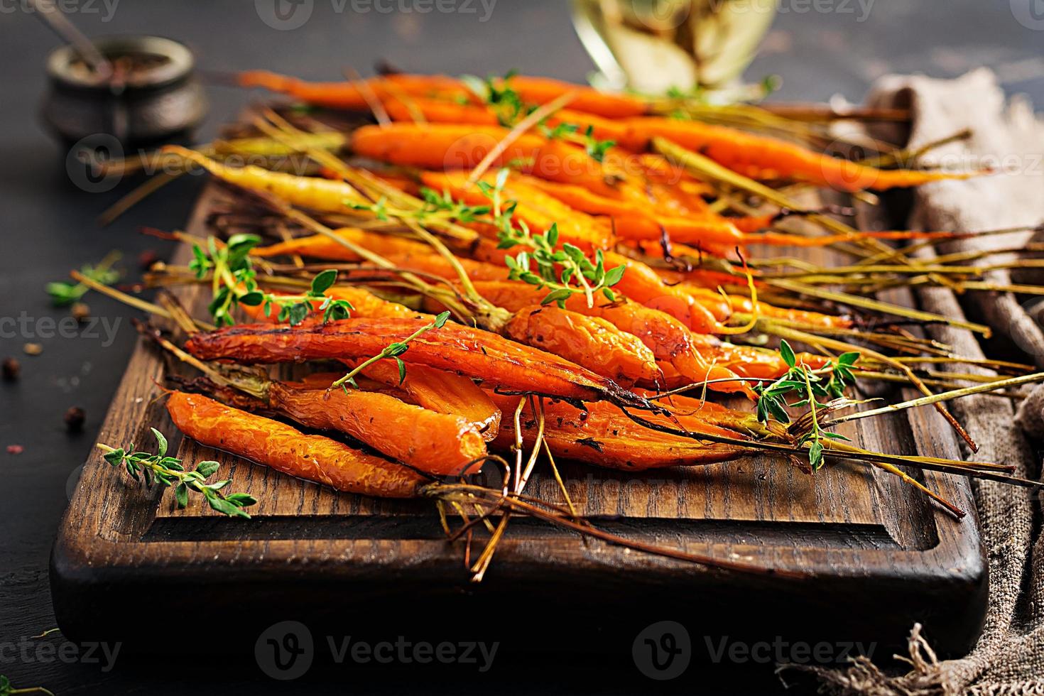 bakad organisk morötter med timjan, honung och citron. organisk vegan mat. foto