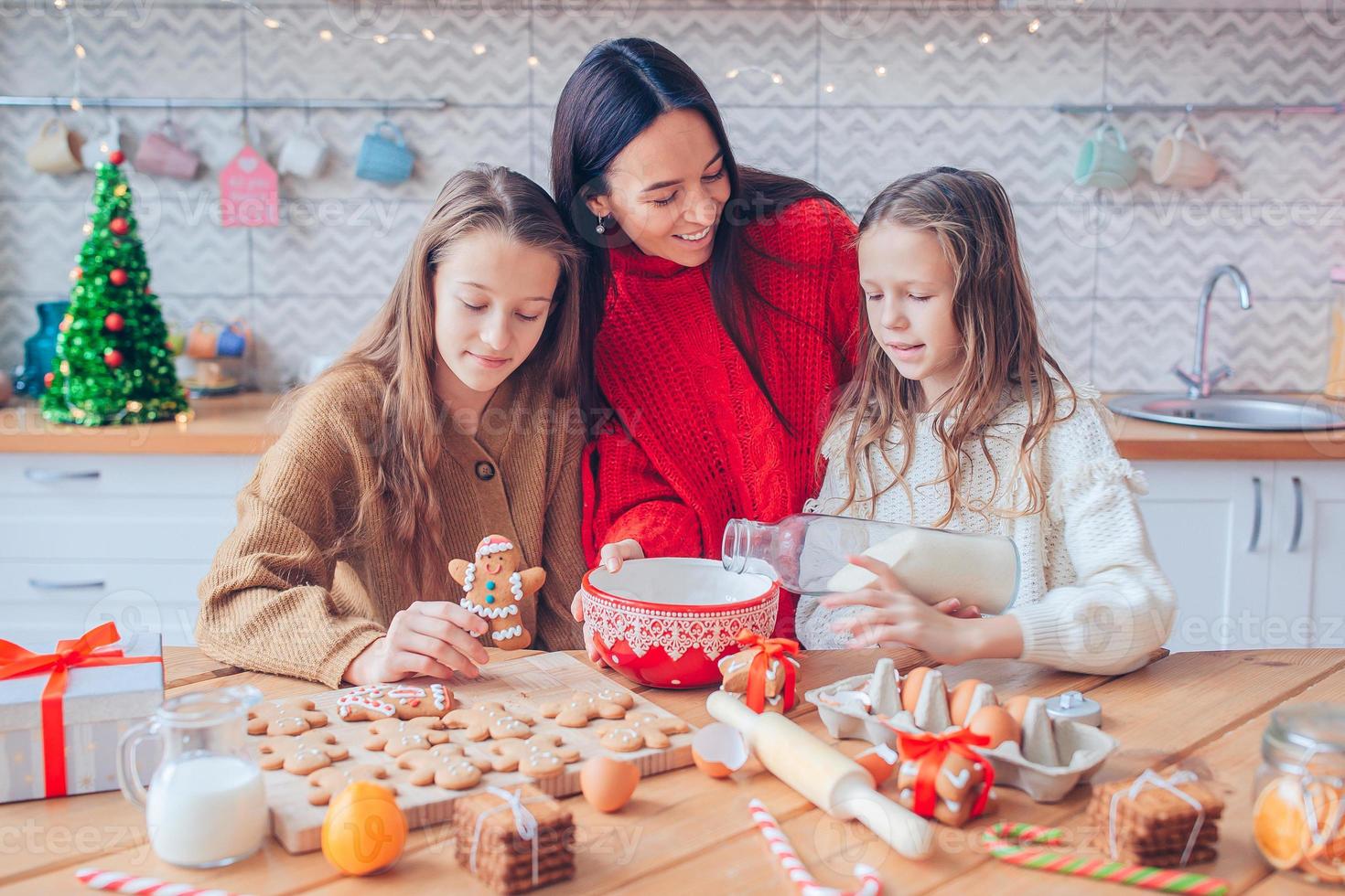 Lycklig familj mor och dotter baka småkakor för jul foto