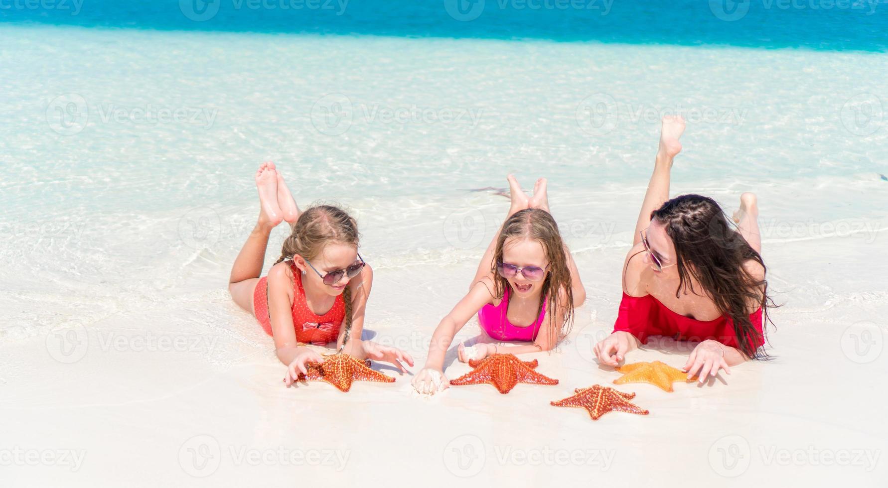 familj av mamma och barn på tropisk strand foto