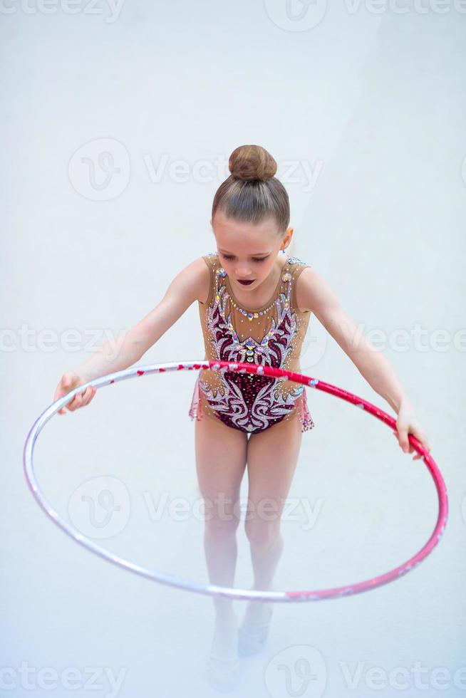 liten gymnast Träning på de matta och redo för tävlingar foto