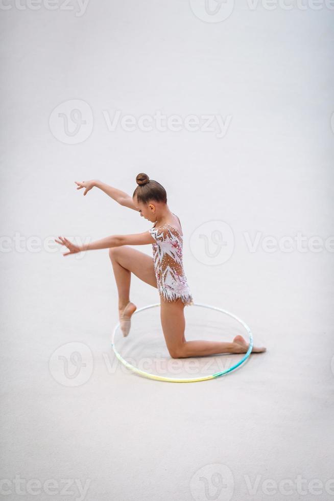 liten gymnast Träning på de matta och redo för tävlingar foto