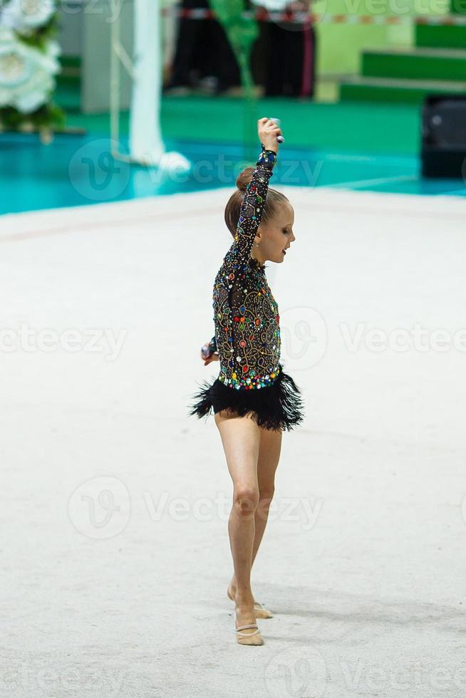 liten gymnast Träning på de matta och redo för tävlingar foto