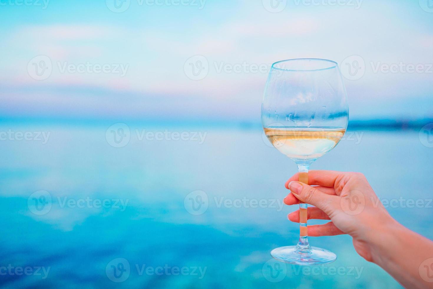 glas av vit vin på tropisk strand foto