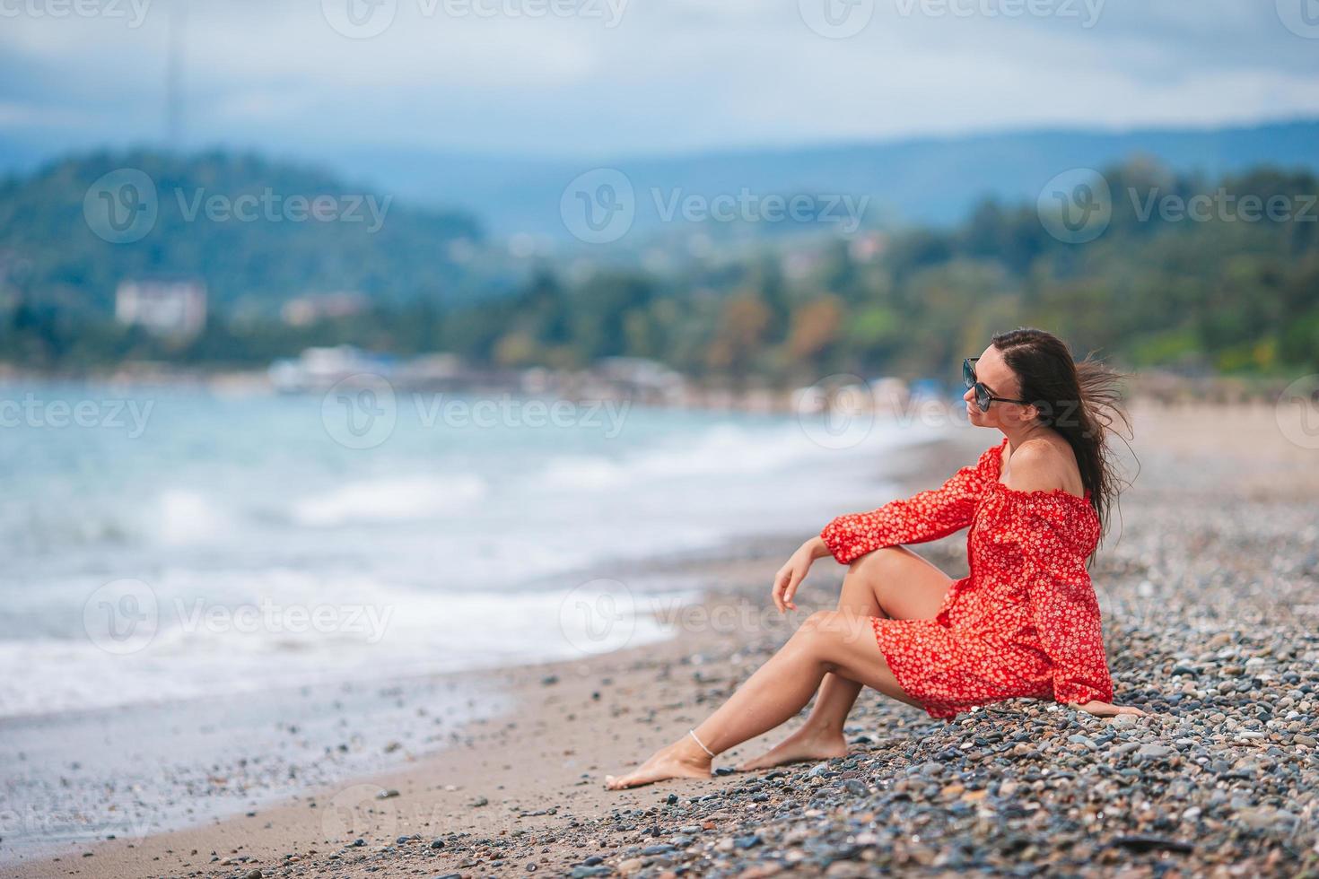 ung Lycklig kvinna på de strand med berg se foto