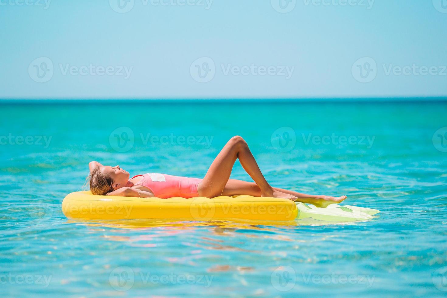 förtjusande flicka på uppblåsbar luft madrass i de hav foto