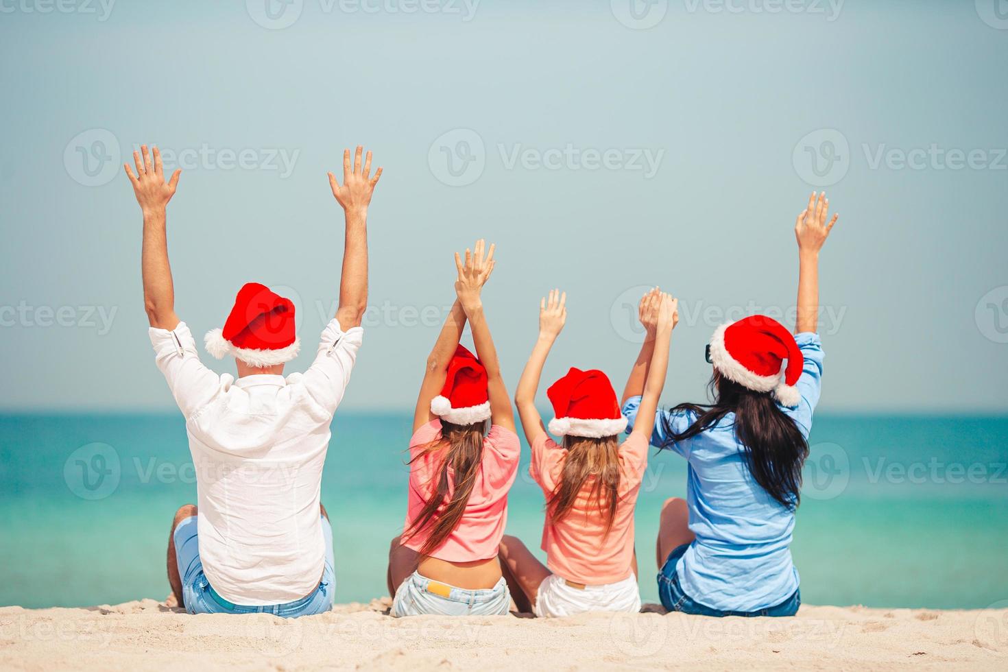 Lycklig familj med två barn i santa hatt på sommar semester foto