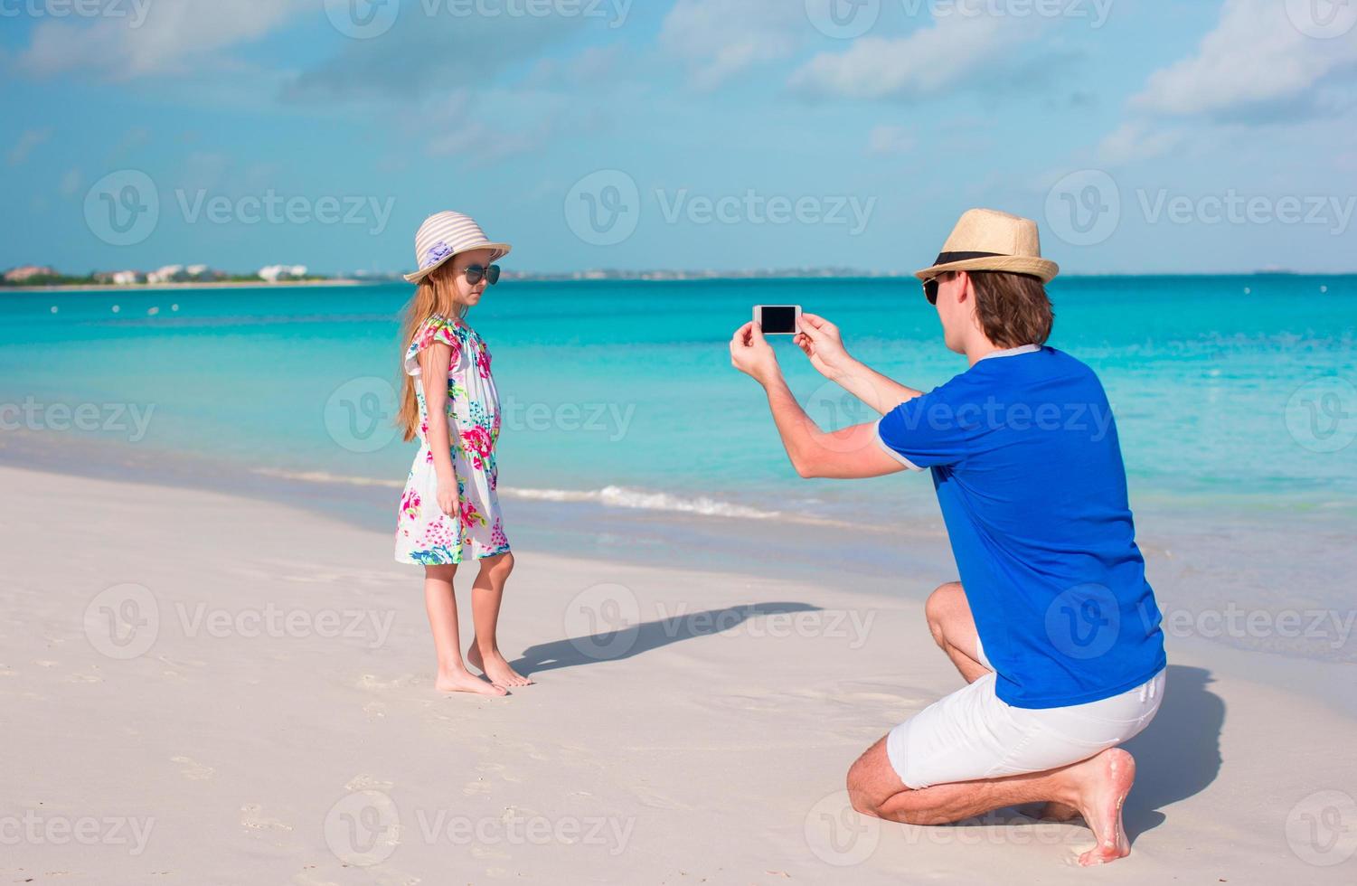 ung far tar Foto på mobiltelefon av hans unge på de strand