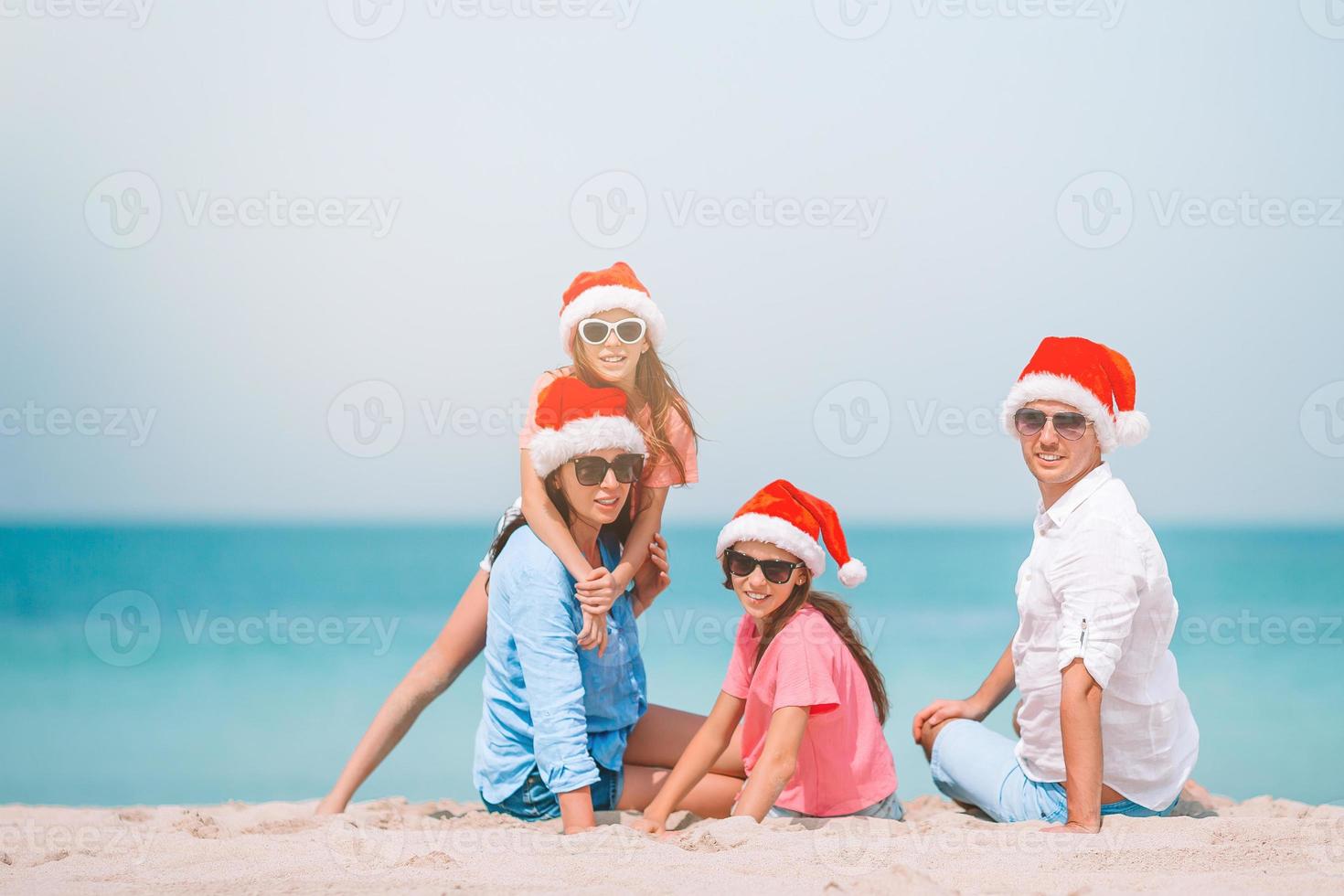 Lycklig familj med två barn i santa hatt på sommar semester foto