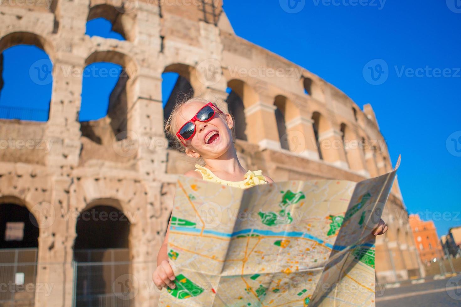 förtjusande liten aktiva flicka med Karta i främre av colosseum i rom, Italien. unge utgifterna barndom i Europa foto