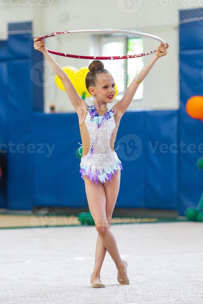 liten gymnast Träning på de matta och redo för tävlingar foto