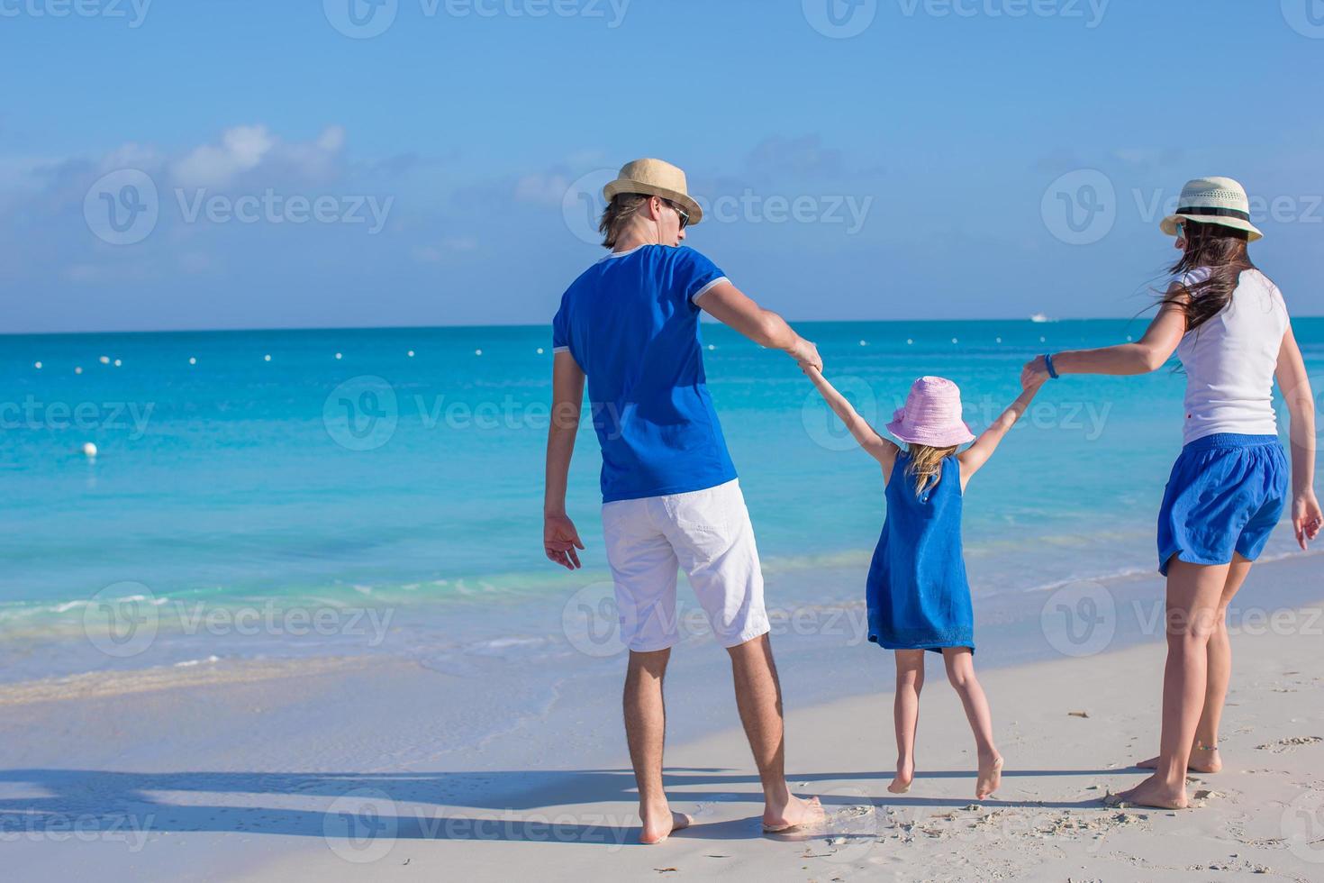 lycklig familj med tre njuter av strandsemester foto