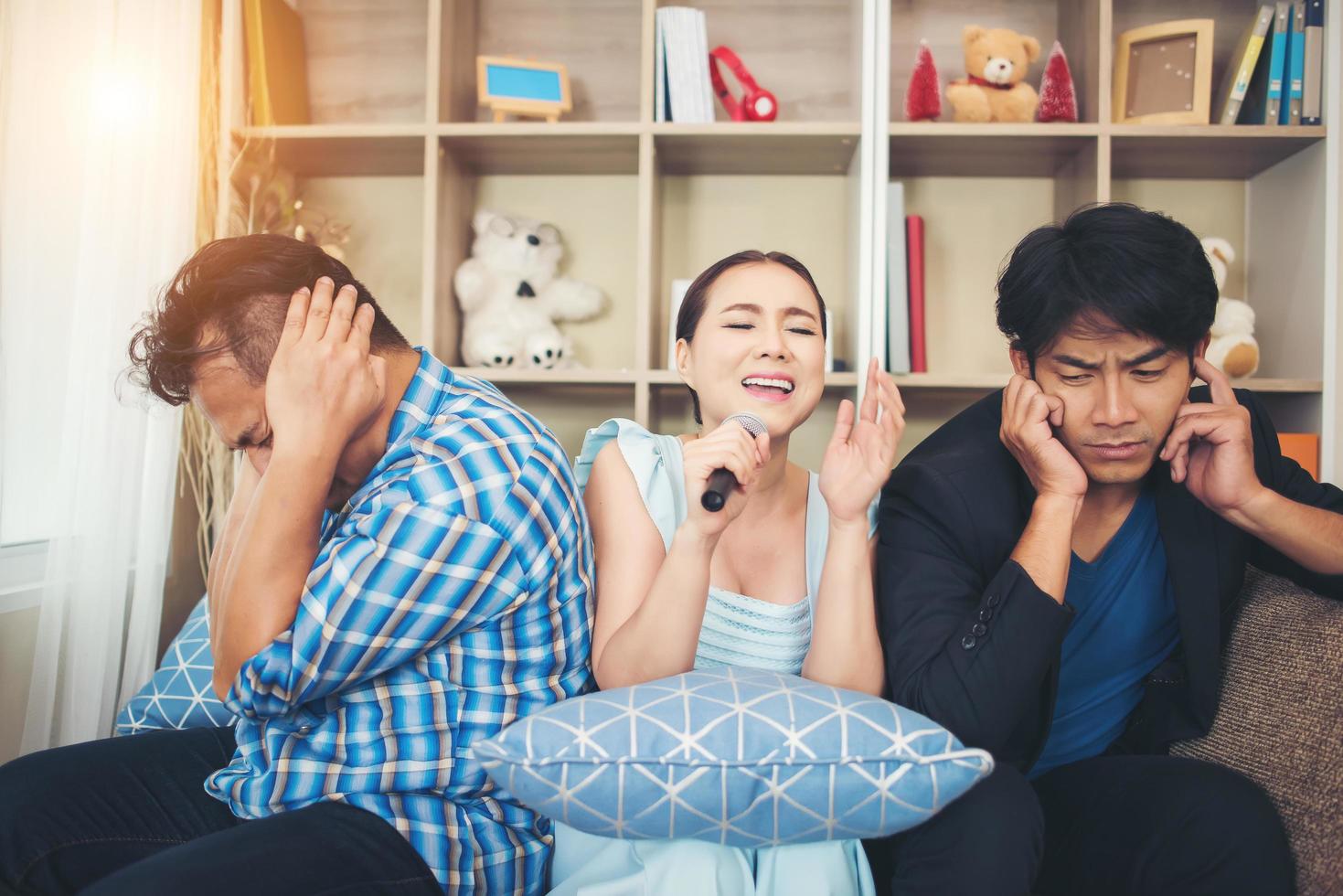 grupp av vänner som sjunger en sång tillsammans i sitt vardagsrum foto