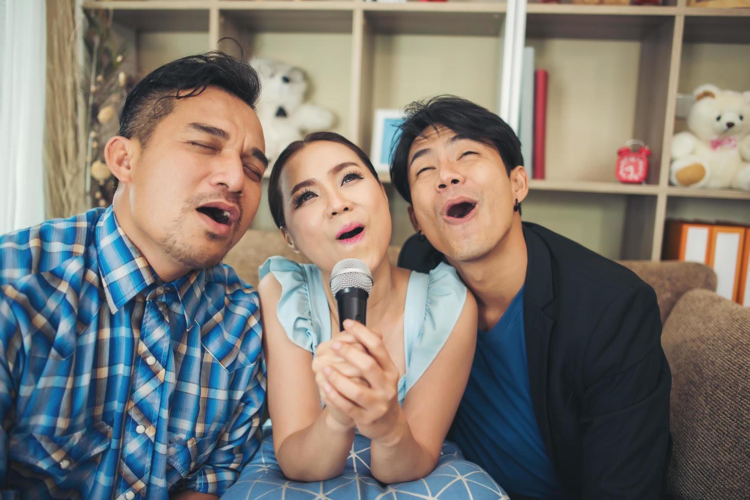 grupp av vänner som sjunger en sång tillsammans i sitt vardagsrum foto