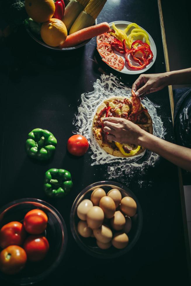 ovanifrån av kvinna som gör hemlagad pizza foto