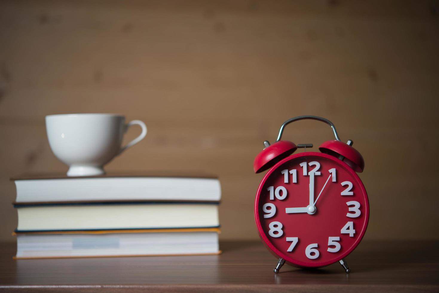 väckarklocka klockan 9 och en bunt böcker med kaffe foto