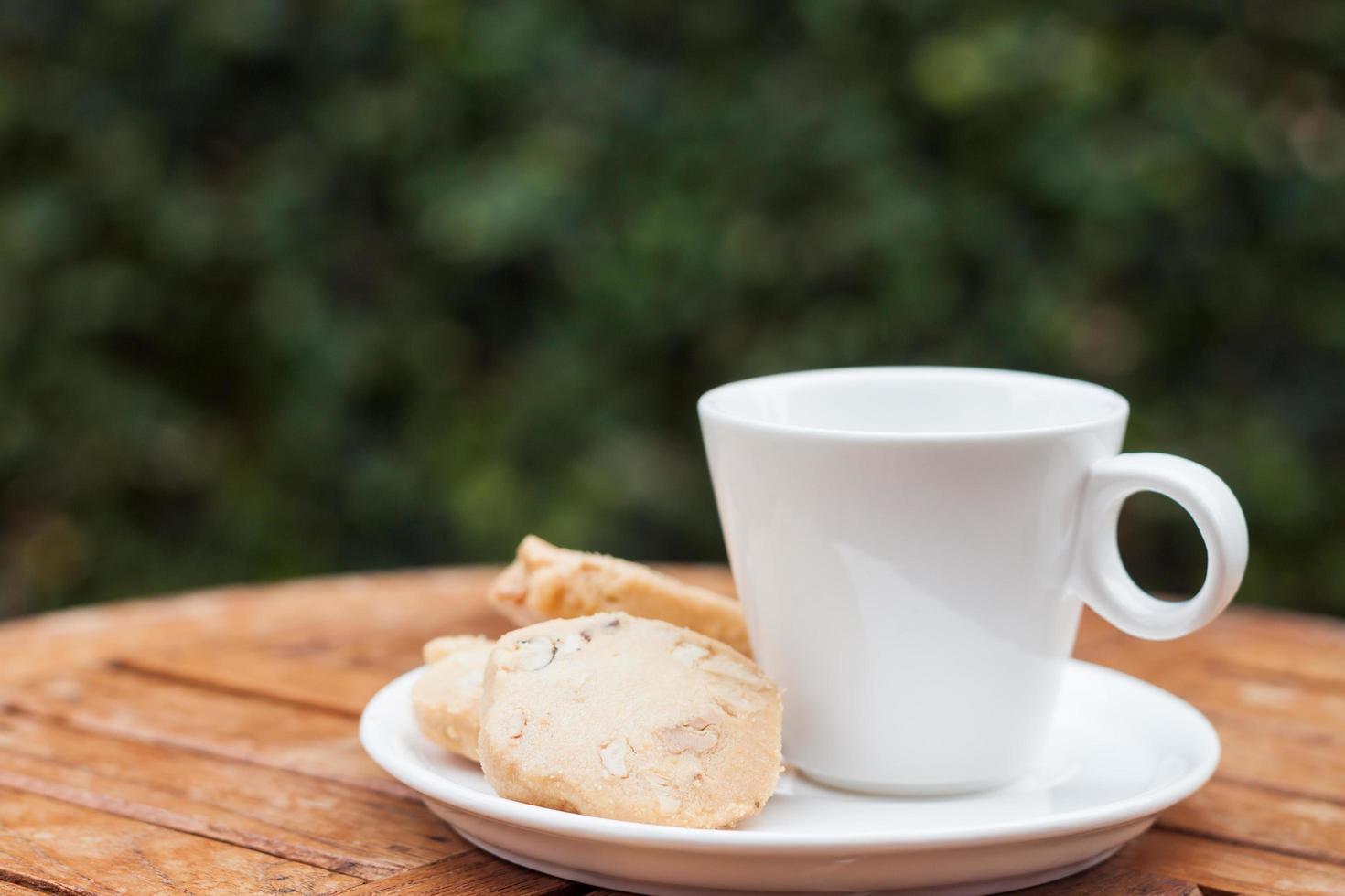 cashewkakor med en vit kaffekopp på ett bord utanför foto