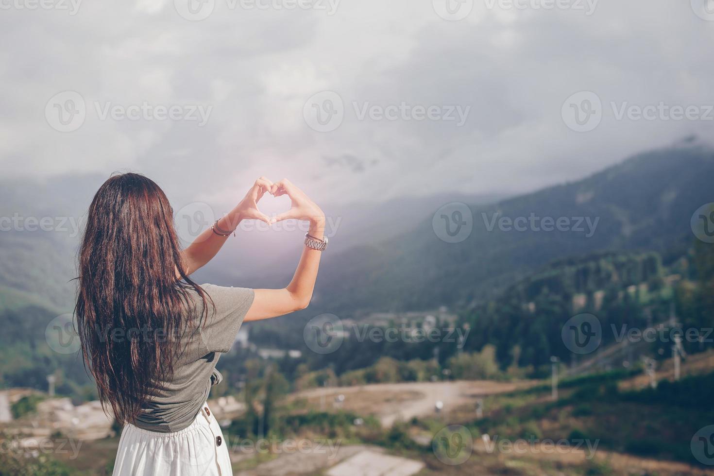 skön Lycklig ung kvinna i bergen i de bakgrund av dimma foto
