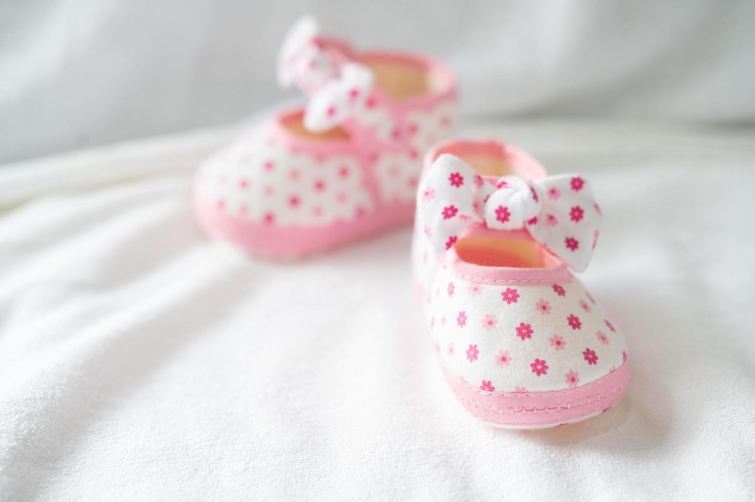 nyfödda skor på vitt sängkläder foto