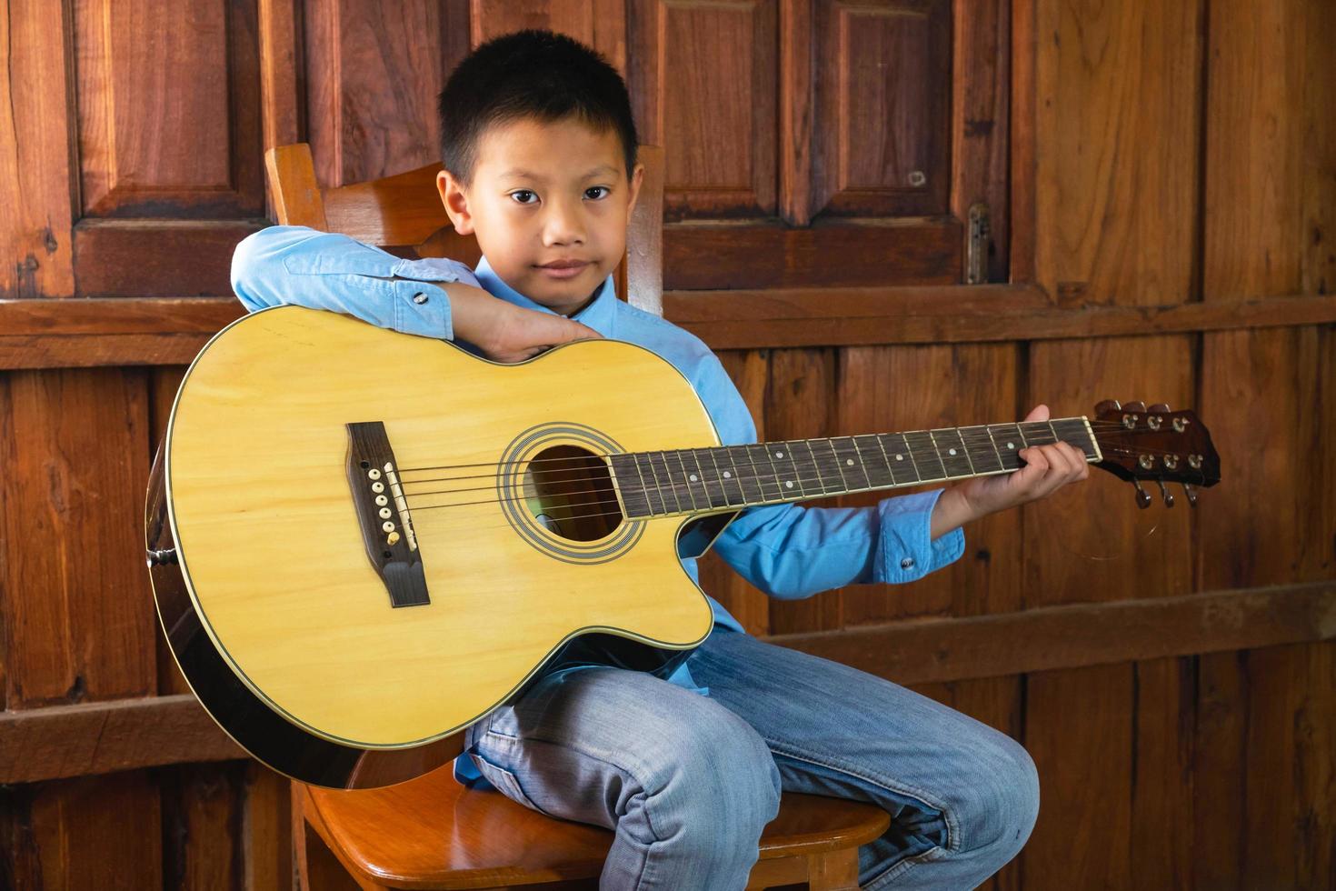 pojke som spelar en gitarr foto