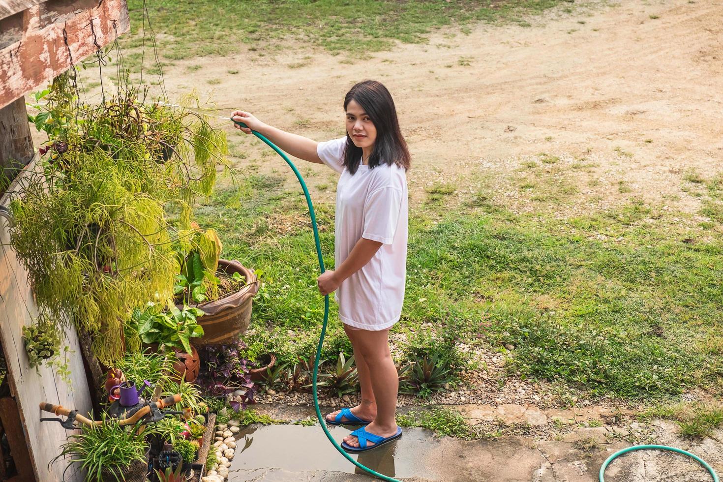 kvinna vattna växter i en trädgård foto