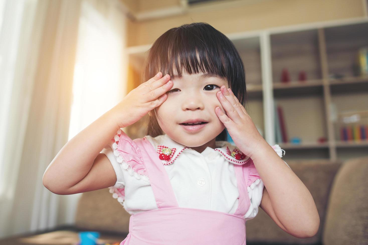 porträtt av en liten asiatisk tjej som leker i sitt hem foto