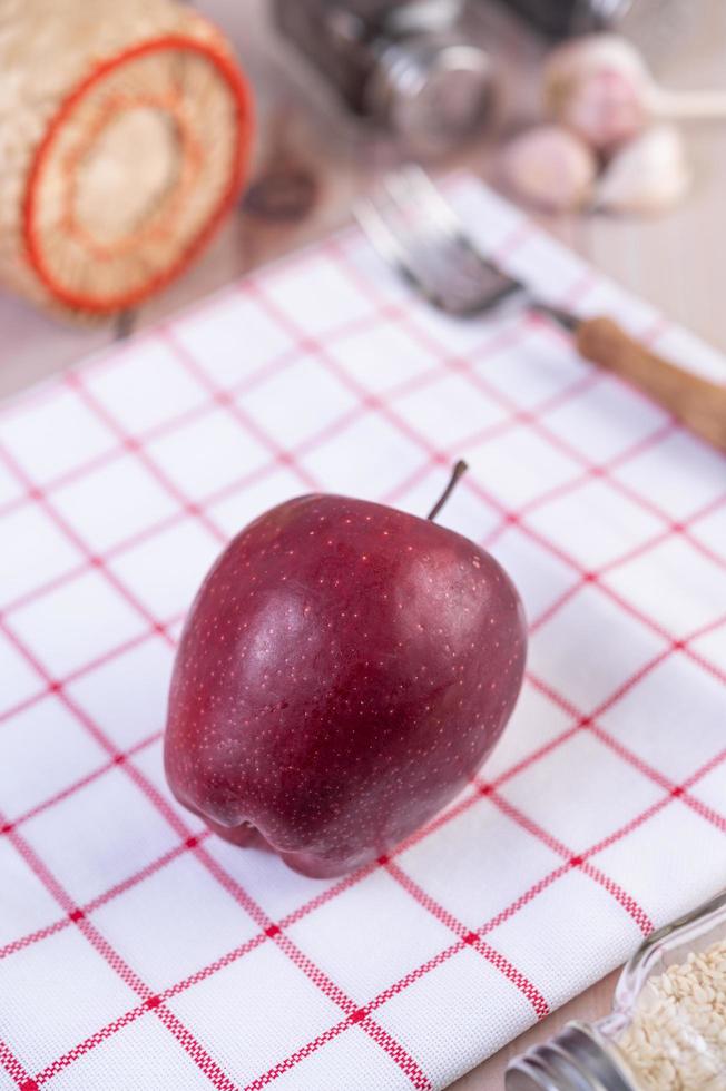 rött äpple på en rödvit kökshandduk foto