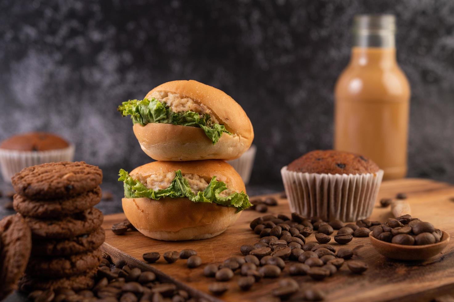 hamburgare på en skärbräda, med muffins och kaffebönor foto