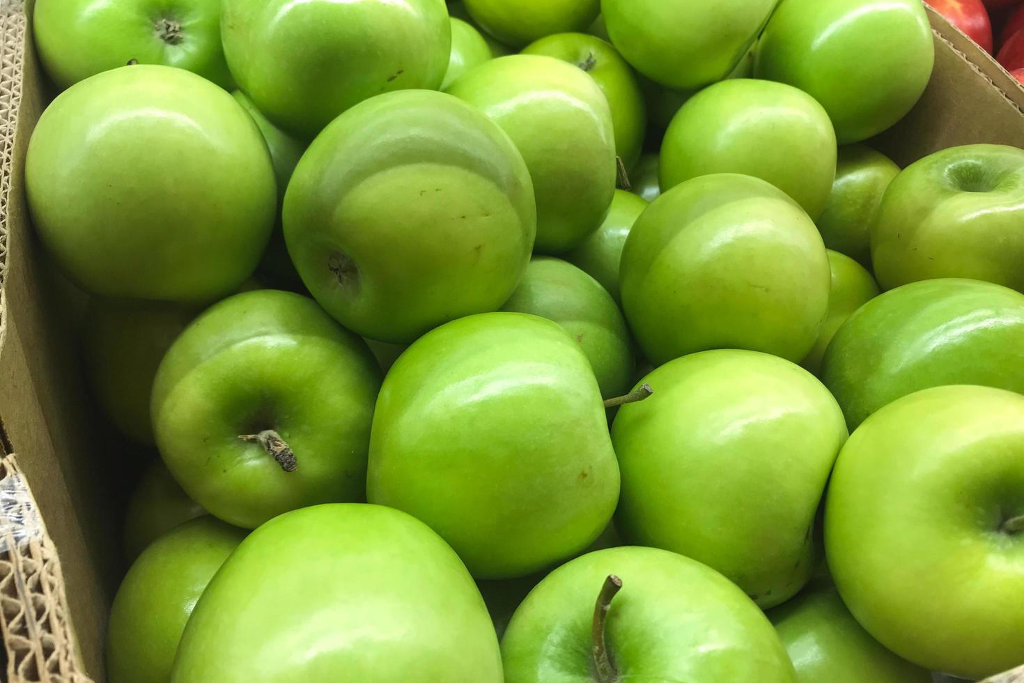 låda med gröna äpplen foto