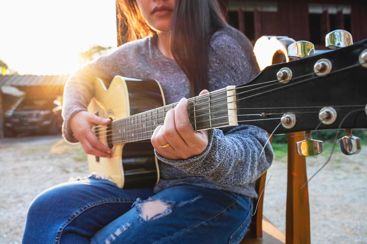 kvinna som spelar en gitarr utanför foto