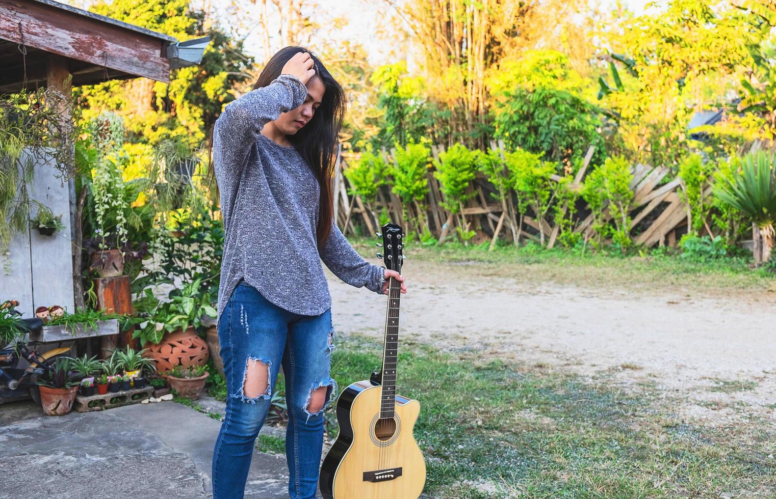 kvinna som håller en gitarr foto