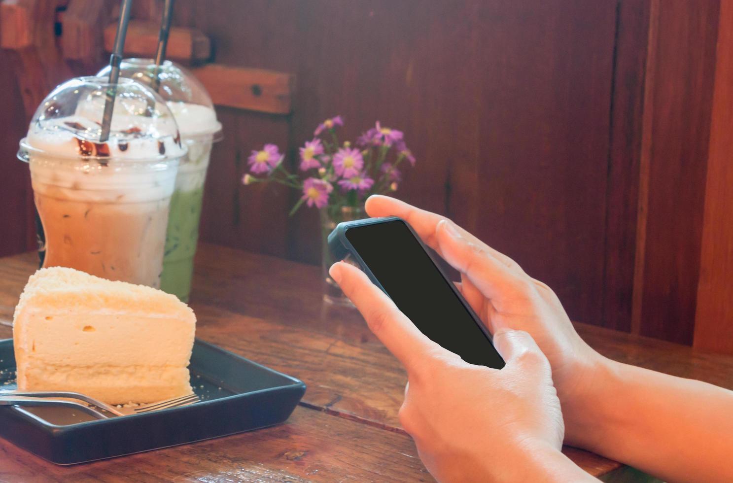 person som använder en telefon i ett kafé foto