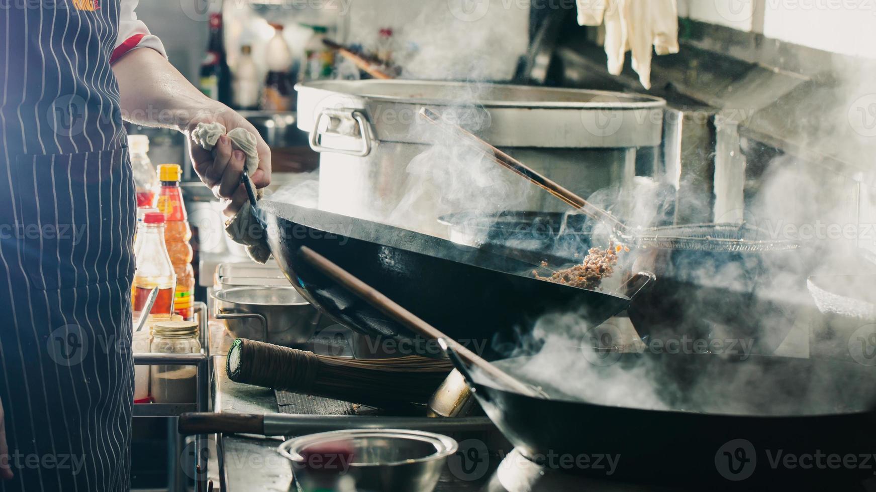 kock som gör en stek i en wok foto