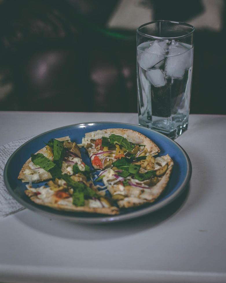 pizza på en blå tallrik foto