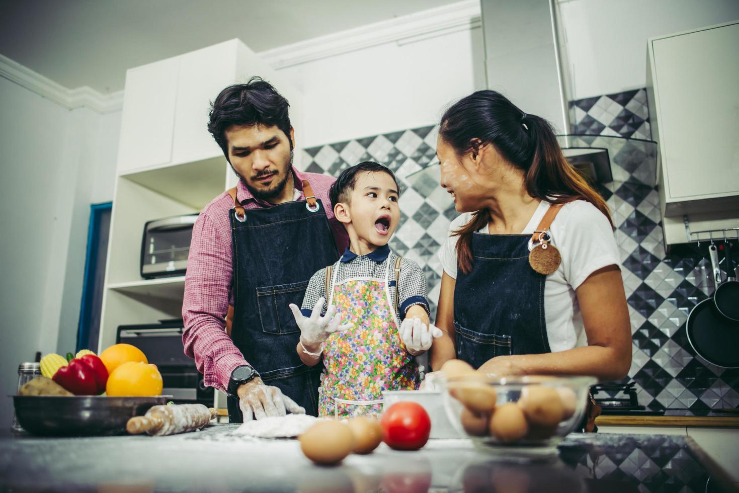 lycklig familj njuter av sin tid att laga mat tillsammans i köket foto