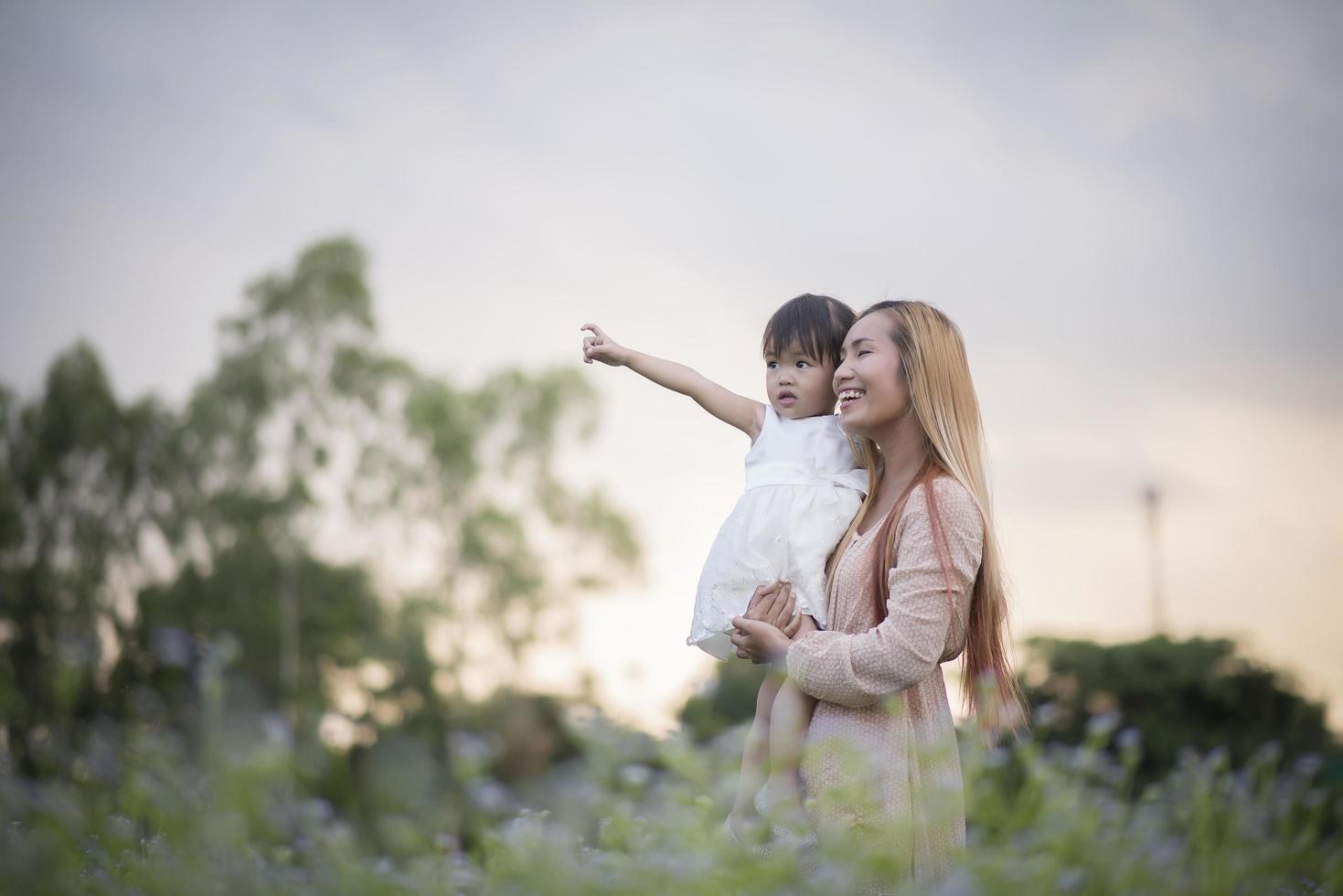 mamma och lilla dotter som leker tillsammans på en äng foto