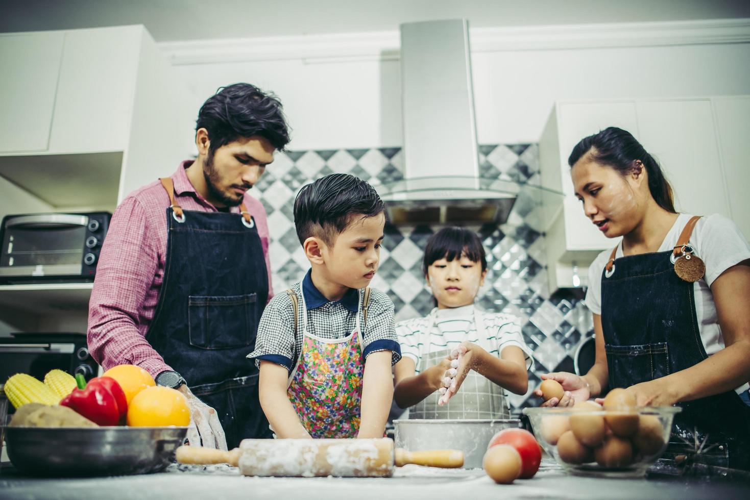 lycklig familj njuter av sin tid att laga mat tillsammans i köket foto