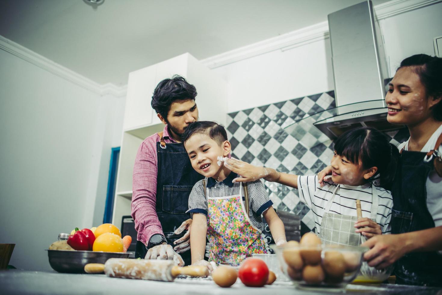 lycklig familj njuter av sin tid att laga mat tillsammans i köket foto