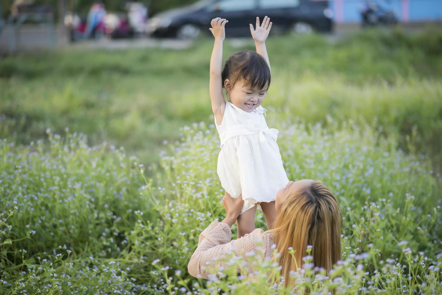 mamma och lilla dotter som leker tillsammans på en äng foto