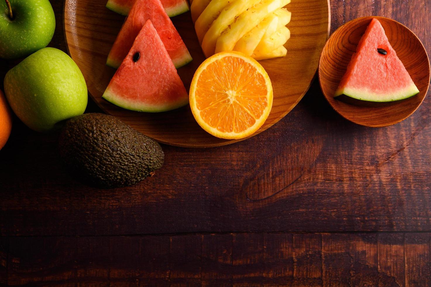 färgrik vattenmelon, ananas, apelsiner med avokado och äpplen foto