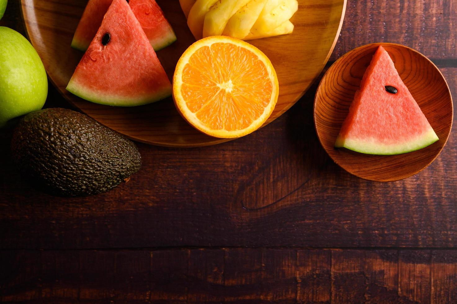 färgrik vattenmelon, ananas, apelsiner med avokado och äpplen foto