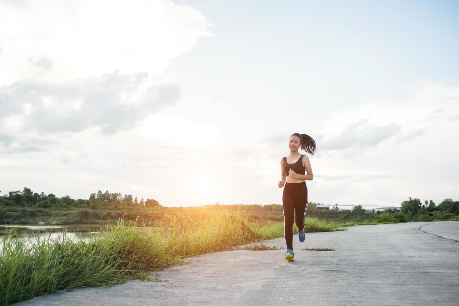 en ung glad kvinnlig löpare som joggar utomhus foto