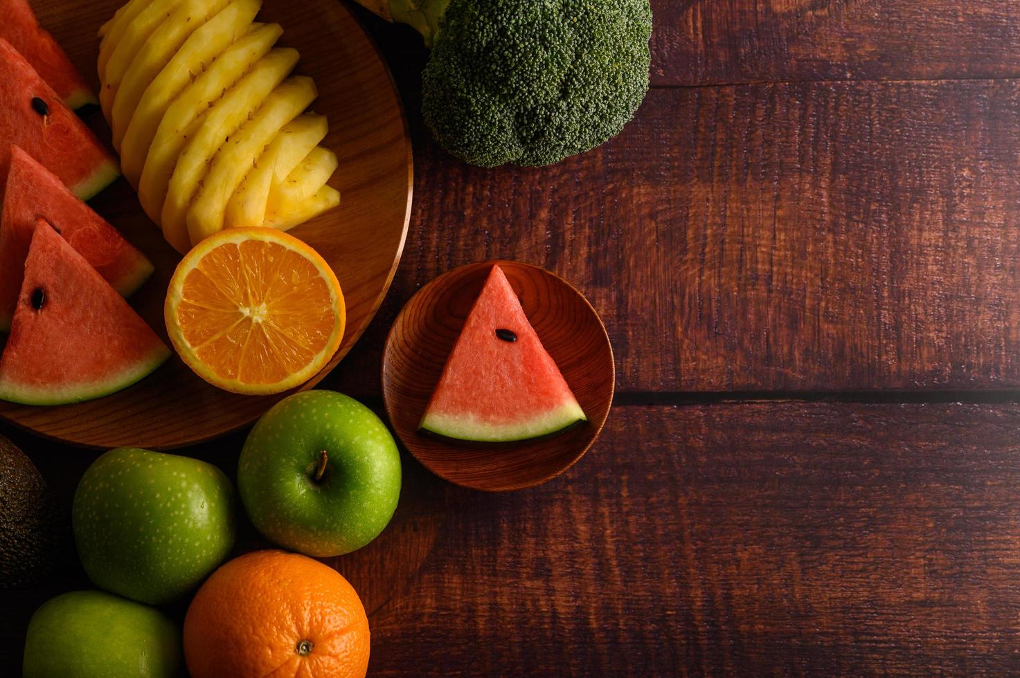 färgrik vattenmelon, ananas, apelsiner med avokado och äpplen foto