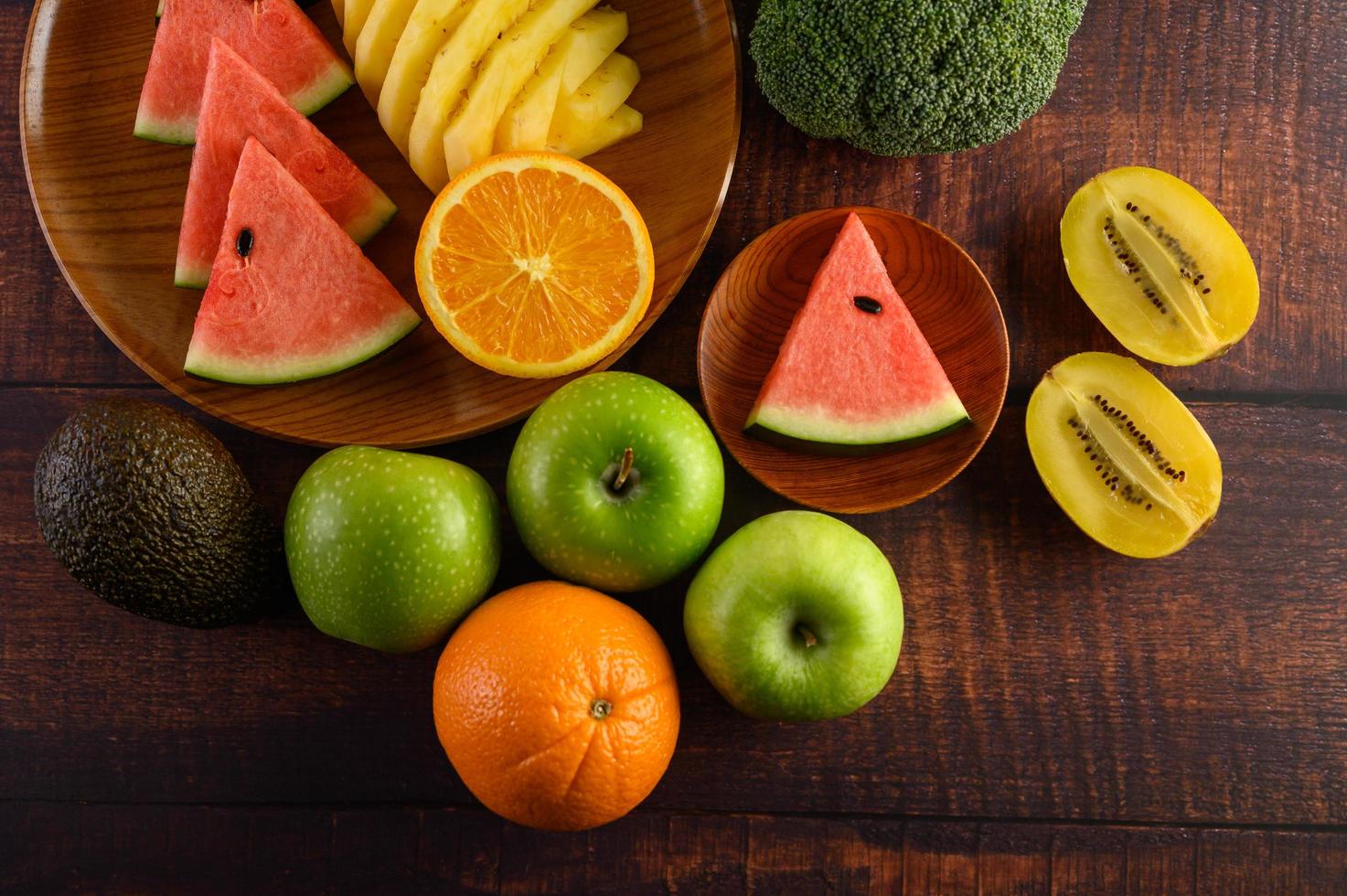 färgrik vattenmelon, ananas, apelsiner med avokado och äpplen foto